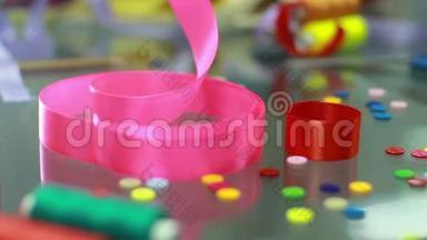 假日装饰品。 手从桌子上拿起粉红色的丝带。 装饰元素